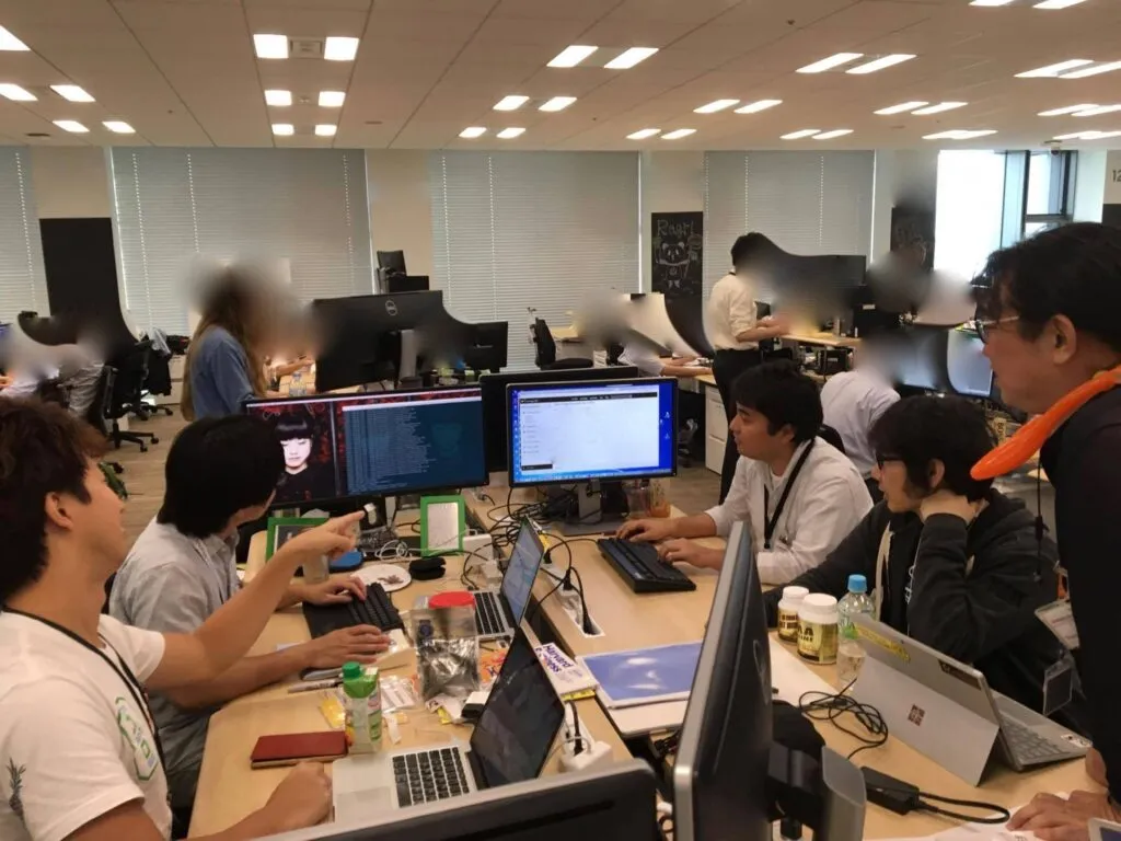 オフィスで1台のディスプレイを囲んでモブプログラミングをするチームの様子