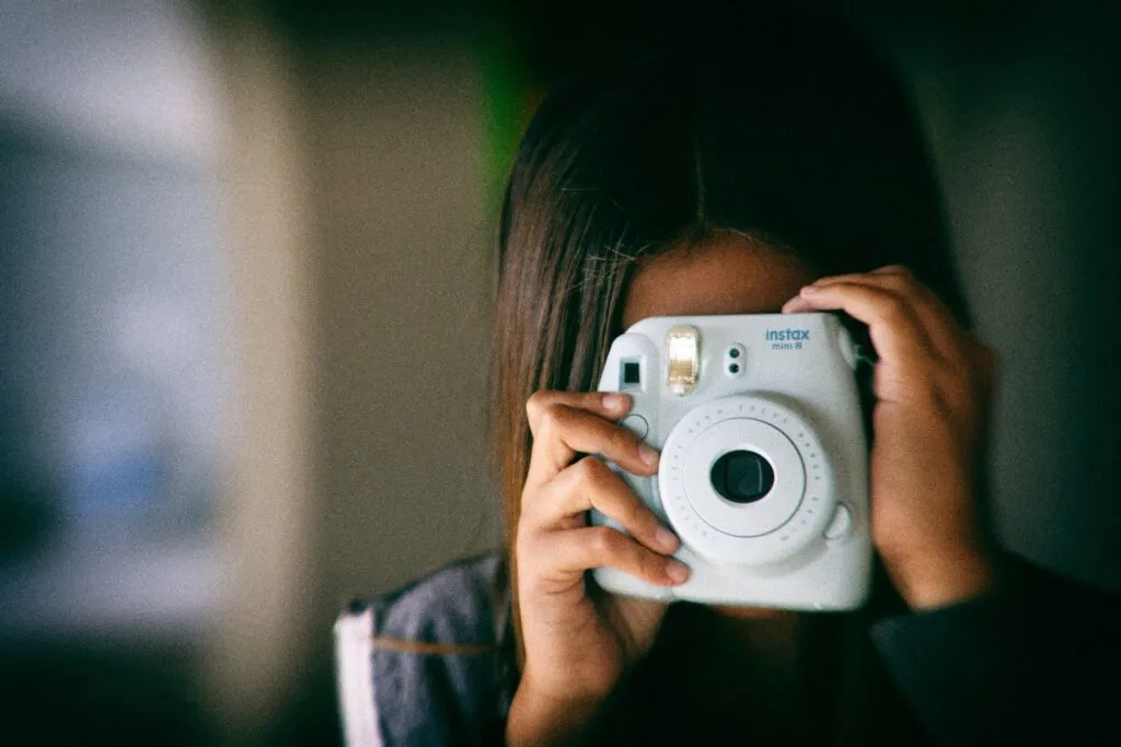 インスタントカメラを構えて写真を撮ろうとしている女性