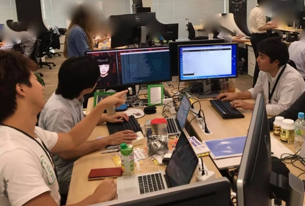 ディスプレイを囲んで一緒に作業するチーム3人の様子